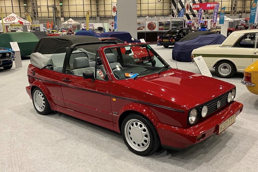 VW Golg convertible on display at a car show with the roof down.
