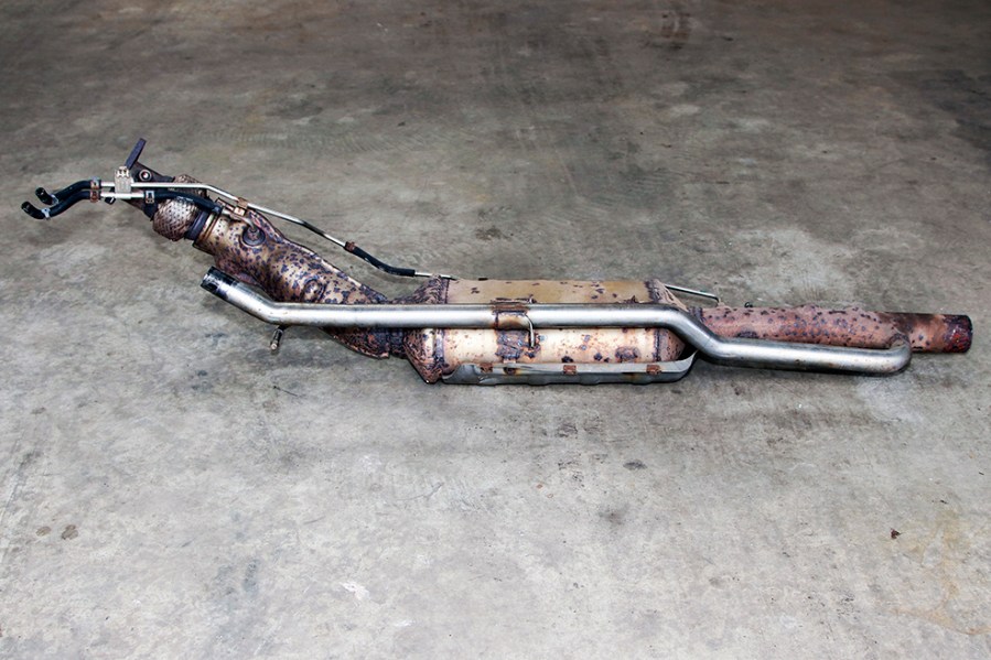 This SCR catalytic converter on this Range Rover Evoque is pictured separated from the rest of the exhaust system. The long pipe is for the low-pressure EGR, which transfers clean, treated gases to the low-pressure EGR cooler within the engine bay.