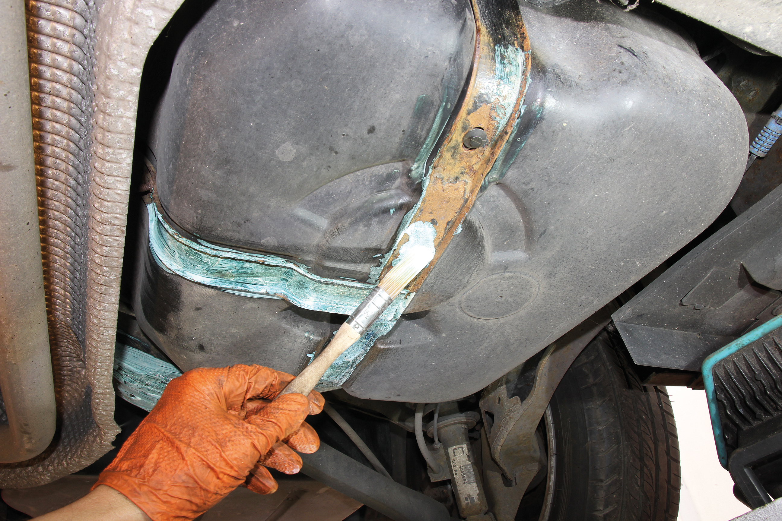 Rusty petrol tank straps are fixed with a wire brush, rust inhibitor, metal paint and a coat of Prolan. 